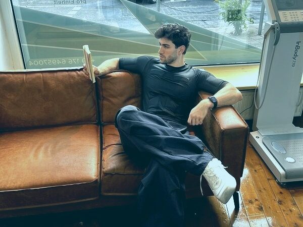 EMS Recovery: Mann entspannt sich im EMS-Anzug auf einem Sofa EMS Recovery: Mann entspannt sich im EMS-Anzug auf einem Sofa