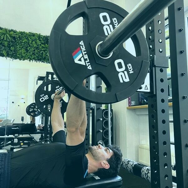 Krafttraining mit EMS: Mann trainiert Bankdrücken im EMS-Anzug im Fitnessstudio Krafttraining mit EMS: Mann trainiert Bankdrücken im EMS-Anzug im Fitnessstudio